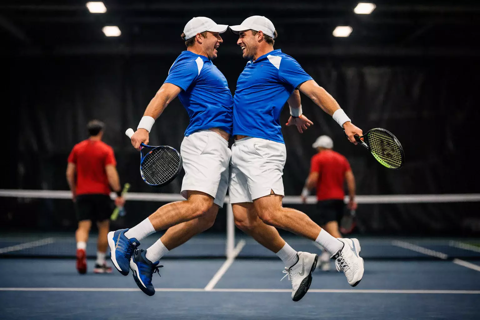 Pareja de dobles de tenis celebrando punto ganador juntos